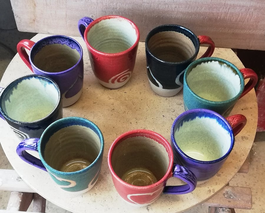 Hearts and spirals decorated, multi colored, ceramic mugs 