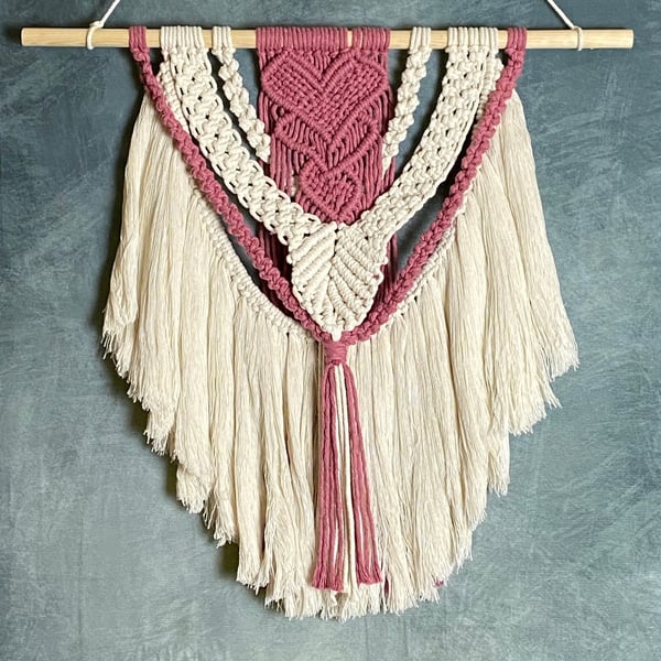 Macrame wall hanging with intricate pink heart knot design