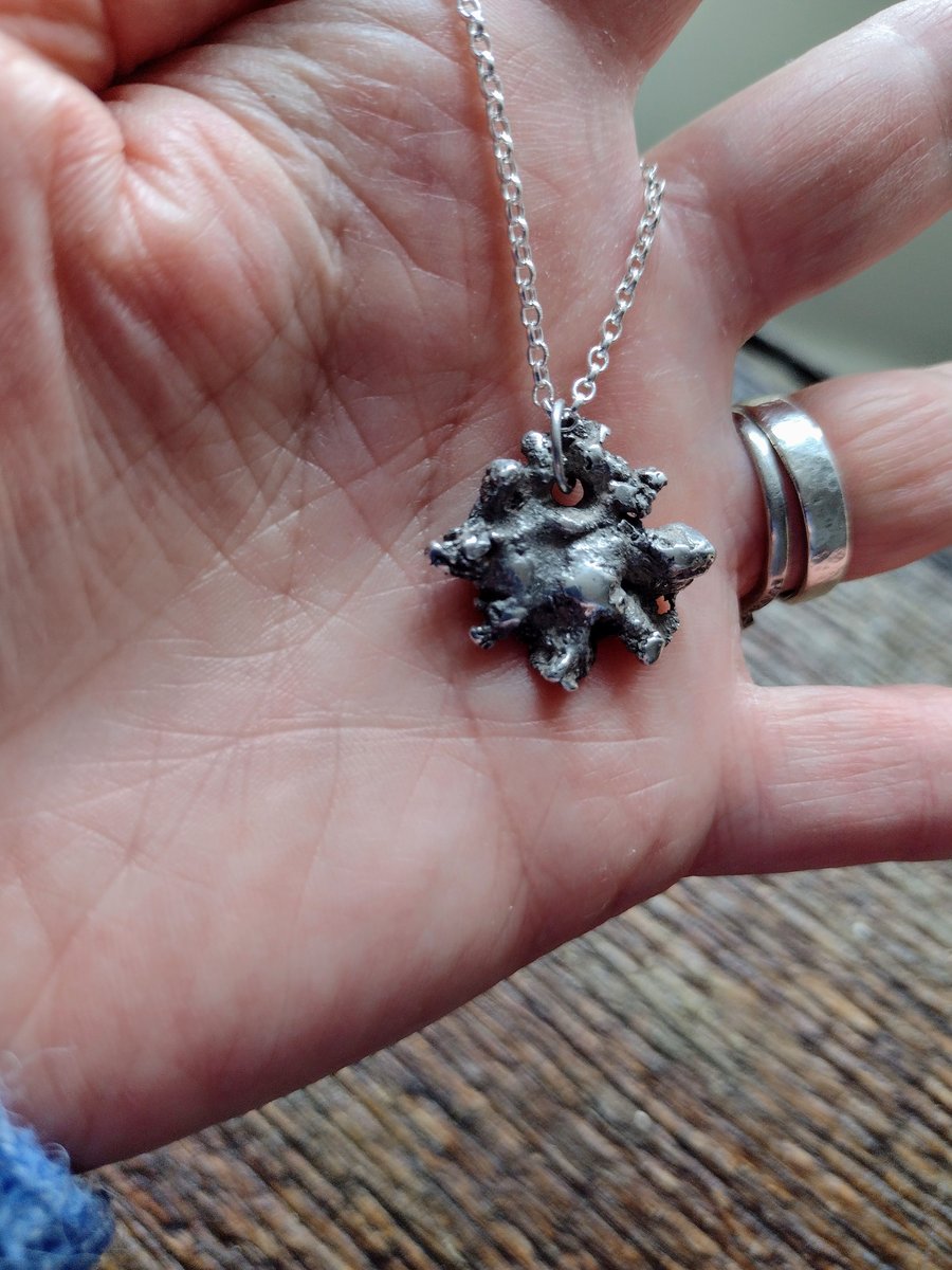 Recycled silver snowflake with a silver necklace.