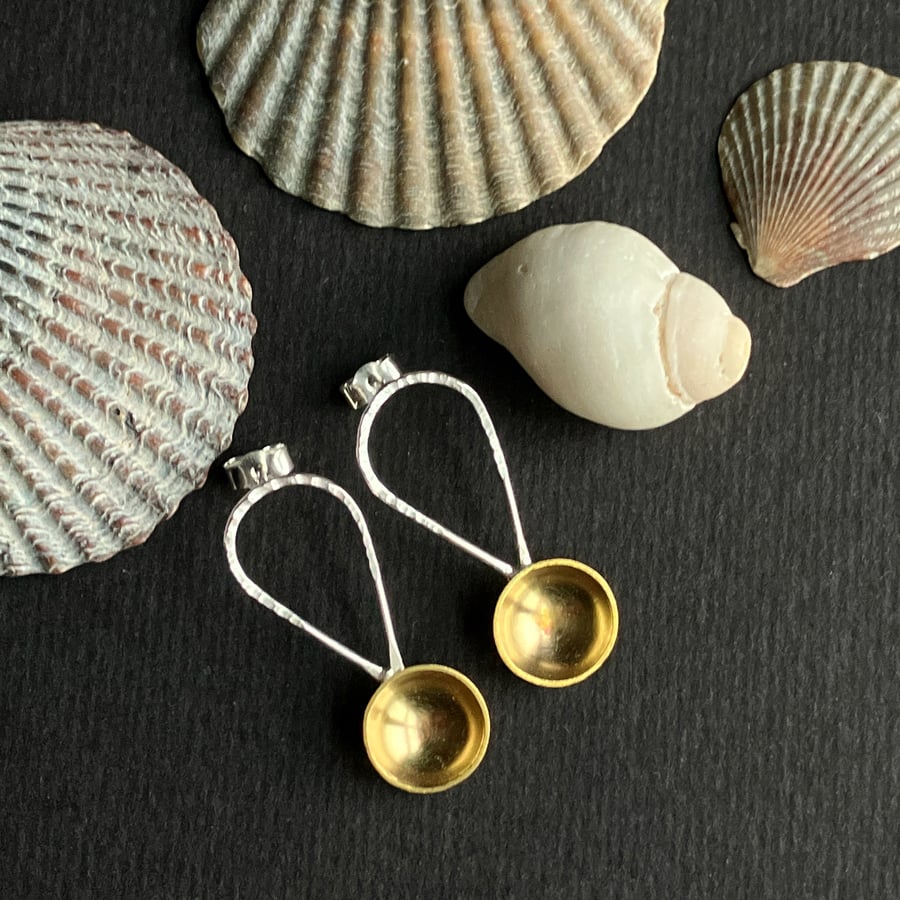 Silver and brass spoon earrings with hammered detail.