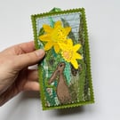 Upcycled embroidered spring rabbit and daffodil home decoration.
