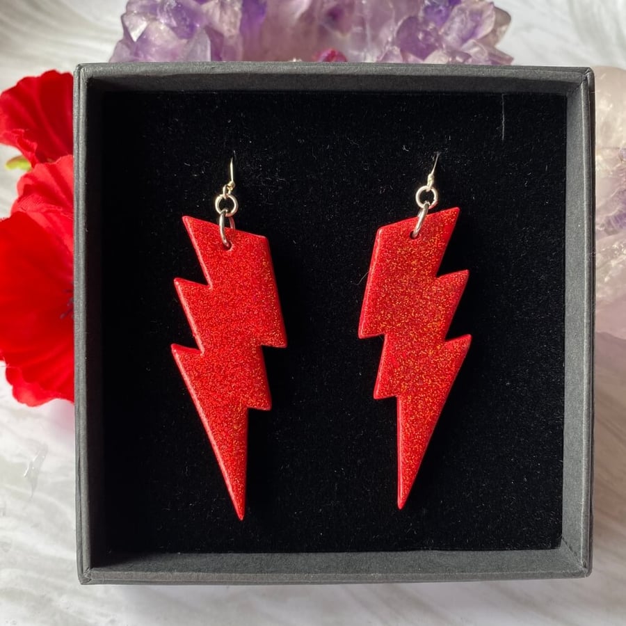 Red lightning bolt glitter earrings.