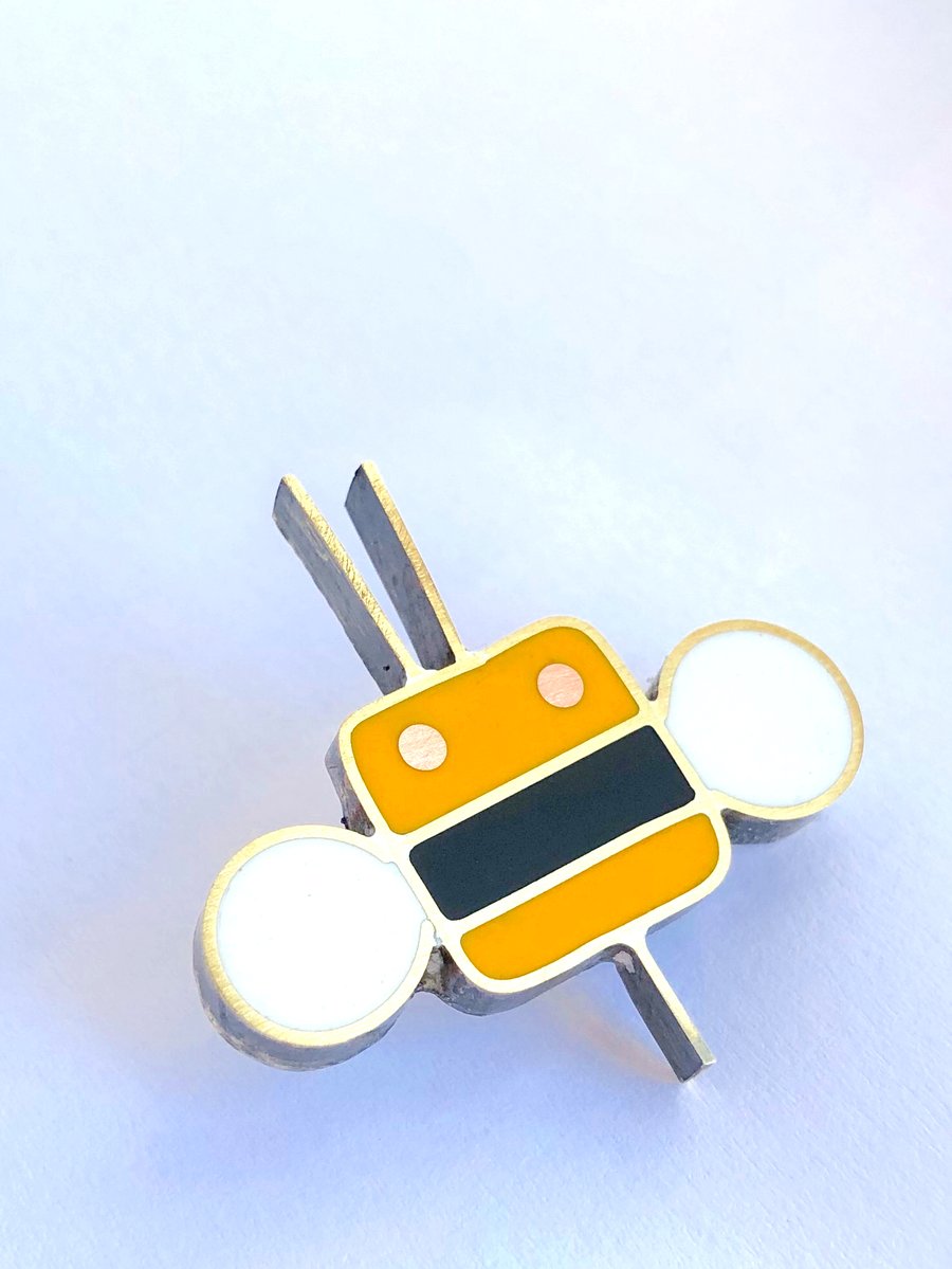 A tiny bee pin brooch in resin and metal