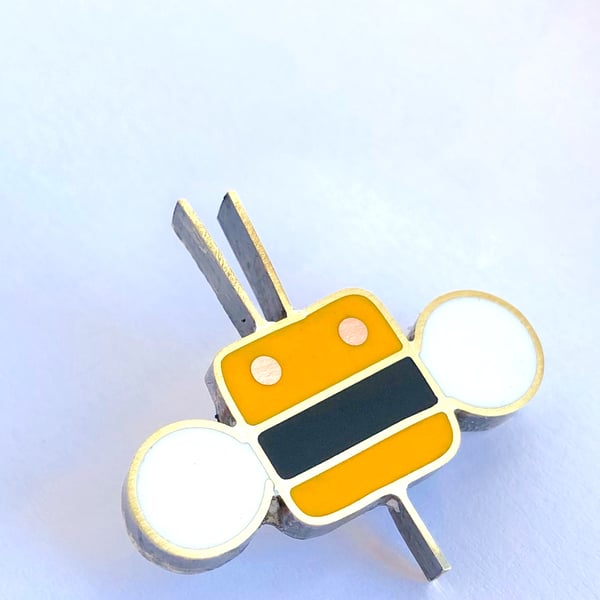 A tiny bee pin brooch in resin and metal
