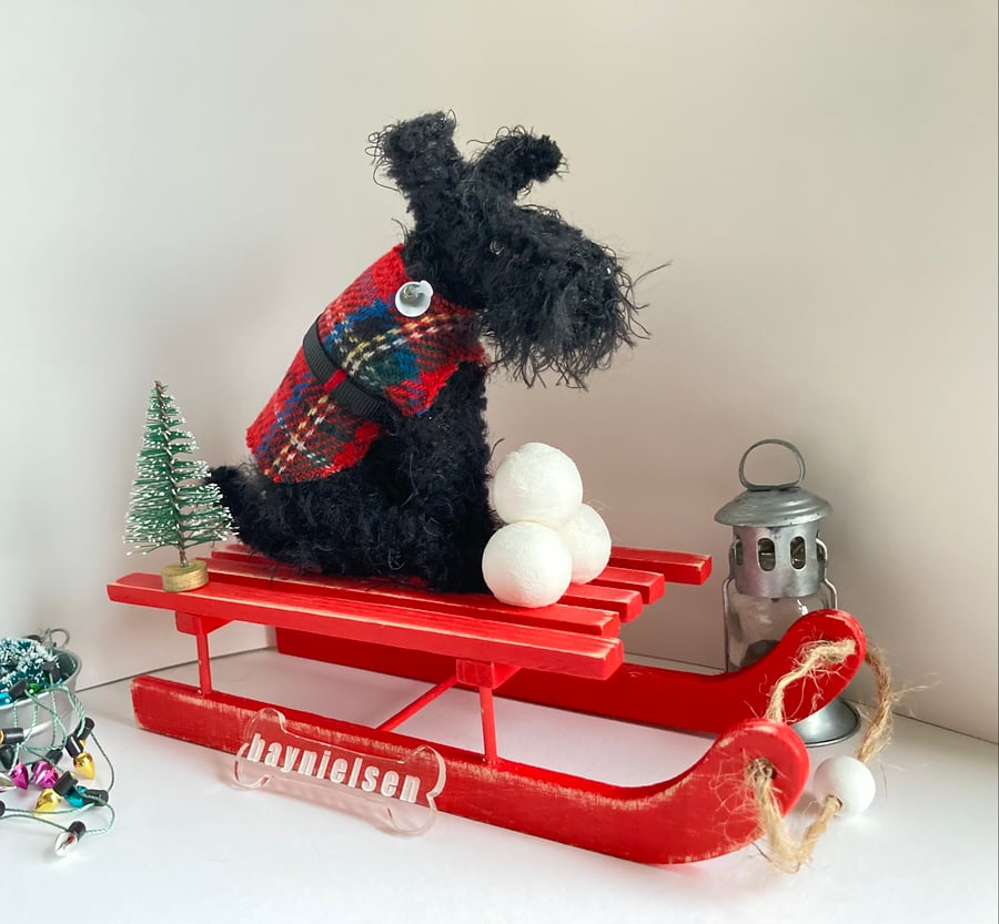Scottish Terrier on a Red Wooden Sledge 