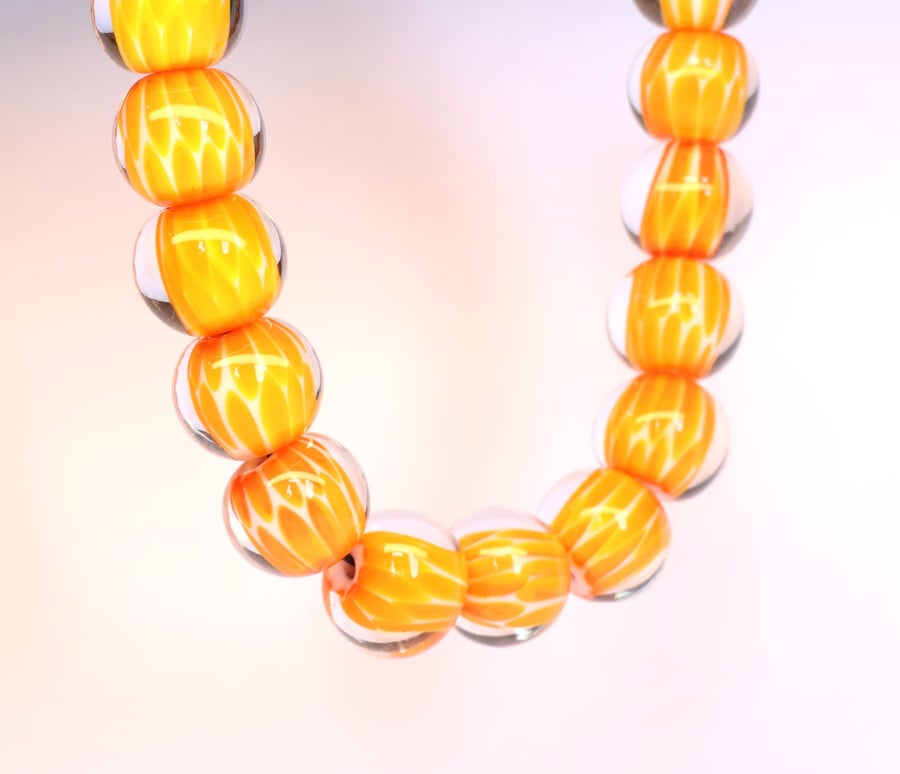 Handmade orange and white patterned lamp work glass beads