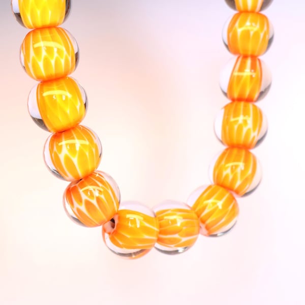 Handmade orange and white patterned lamp work glass beads