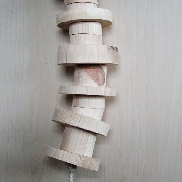 Toy for a caged bird, made from different sized round pieces of smooth pine.