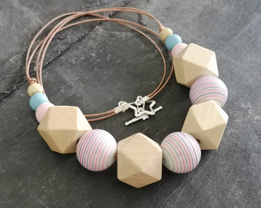 Necklace with pink and blue striped acrylic beads and natural wooden beads