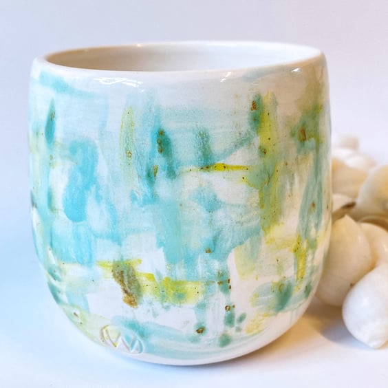 Hand made wheel thrown planter with a hand painted design in greens, blues and y