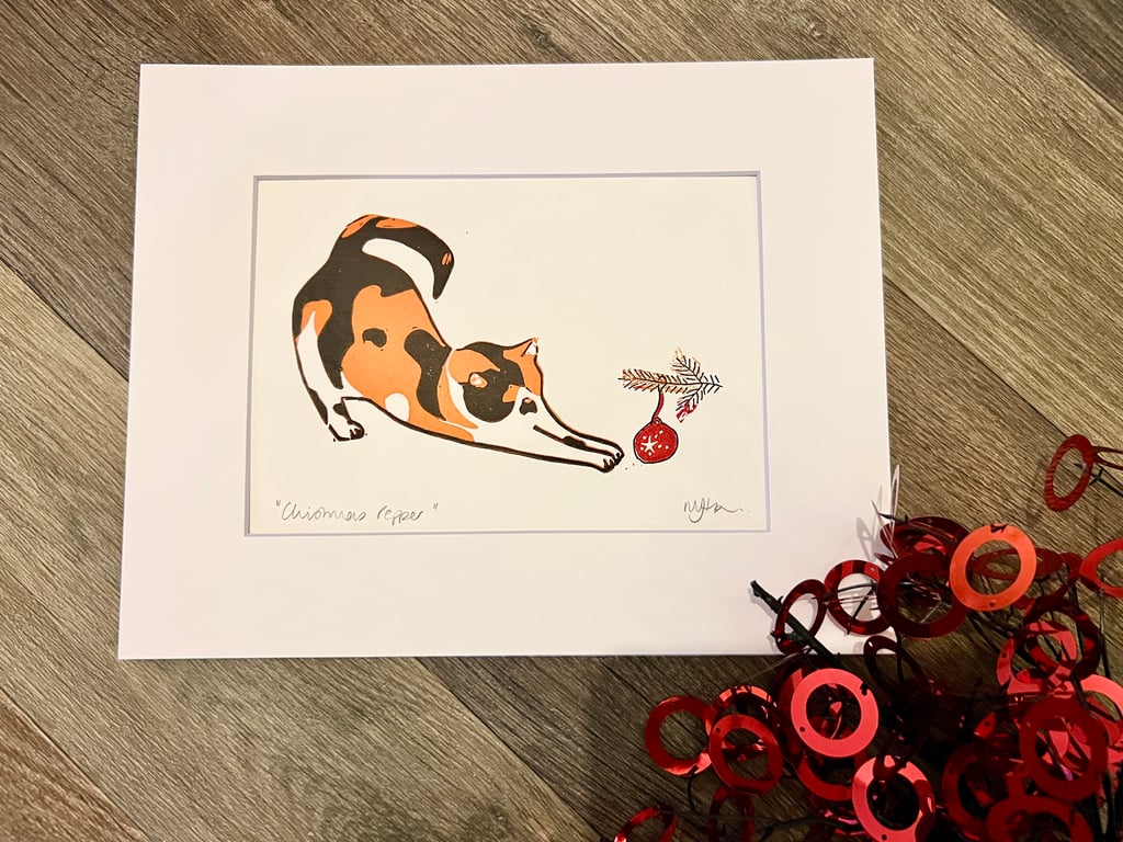 Mounted Christmas cat with bauble reduction lino print 