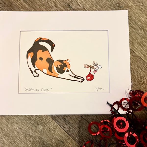 Mounted Christmas cat with bauble reduction lino print 