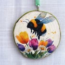 Bee and tulip decoupaged log slice wall decoration.