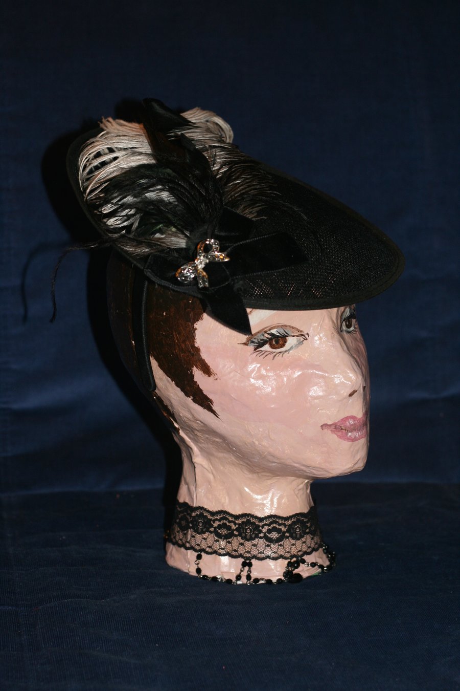 Black disc hat with double bow and feathers
