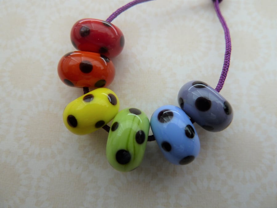 handmade lampwork rainbow glass beads with black spots set