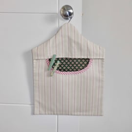Peg bag in striped canvas fabric with dark green lining and red trim.
