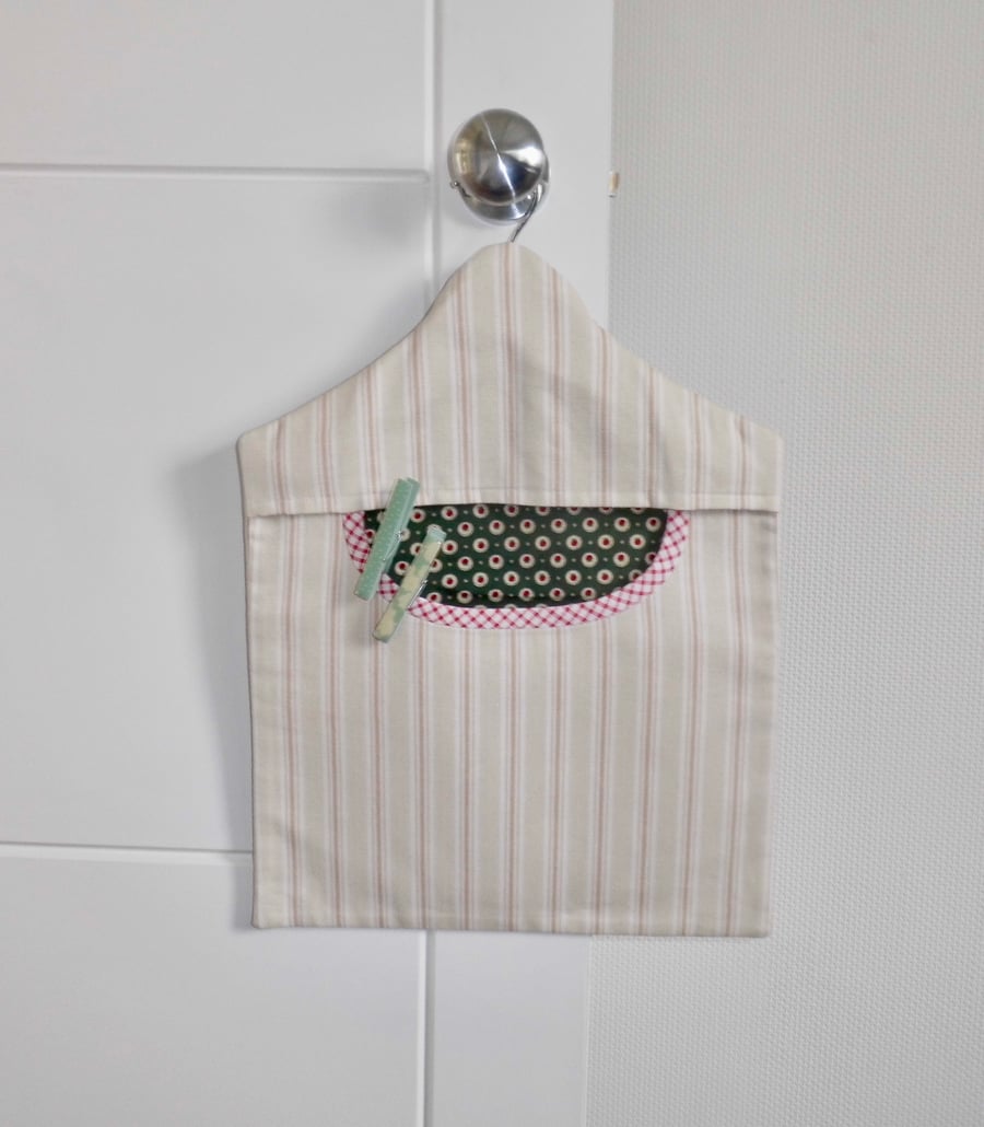 Peg bag in striped canvas fabric with dark green lining and red trim.