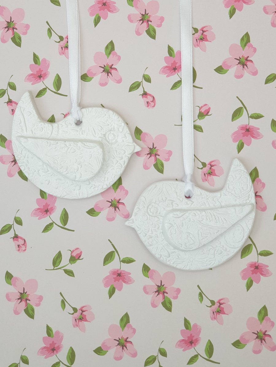 Pair of white hanging bird embossed clay decorations 