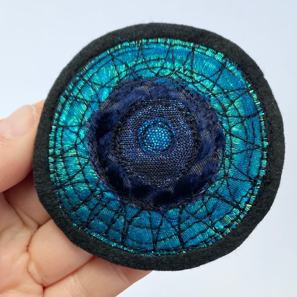 Embroidered circular sun brooch pin of badge. 