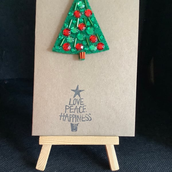 A handmade, felt,  Christmas Tree brooch, attached to a hand stamped kraft card