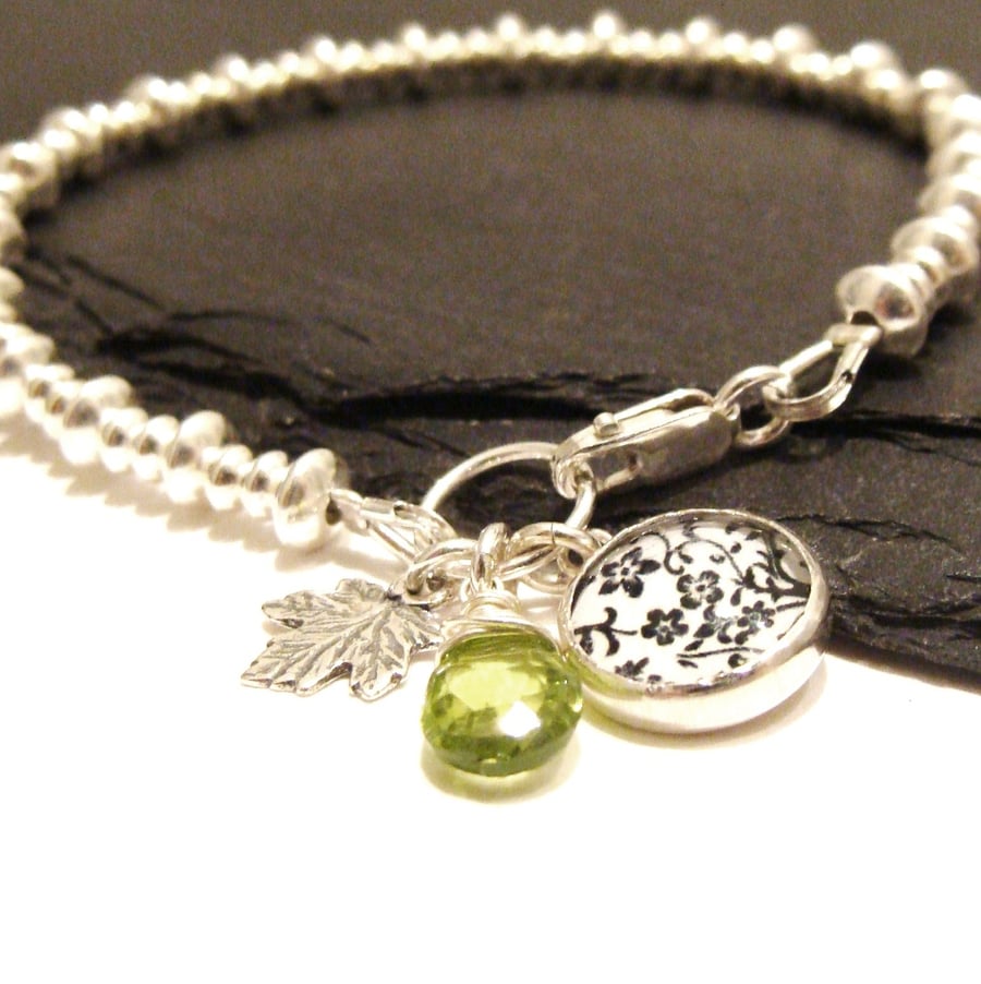 Sterling Silver Beaded Bracelet with Floral Art Charm, Leaf Charm and Peridot