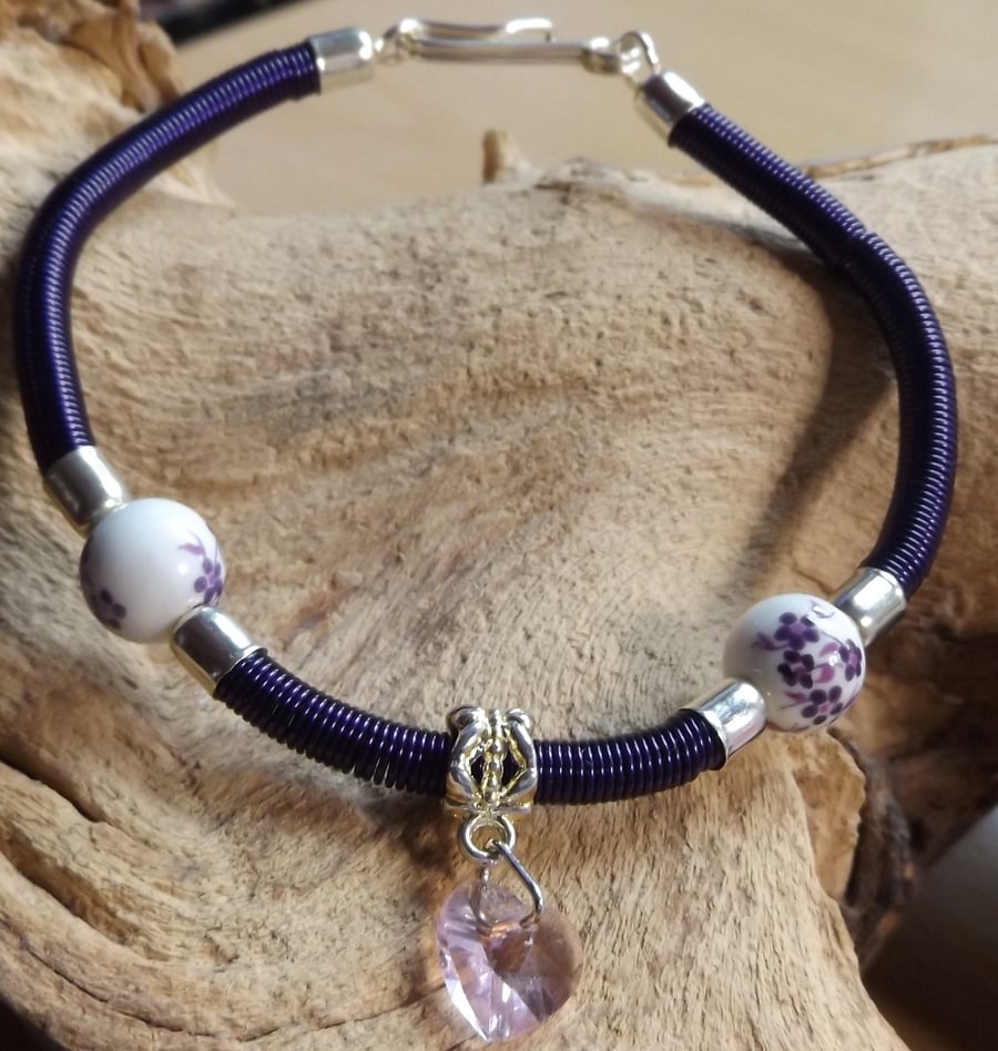 Gizmo purple coiled bracelet with porcelain flower beads with pink crystal heart