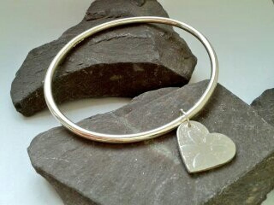 Silver bangle with flower heart charm