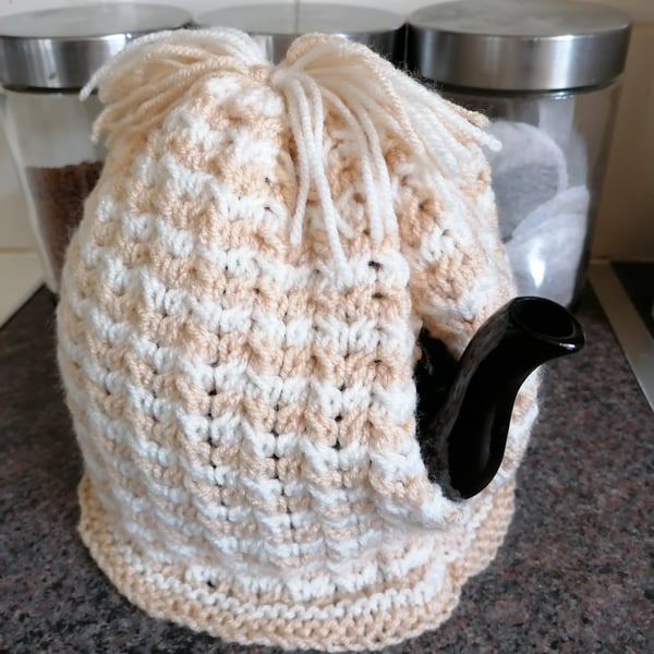 Beige and white striped twist stitch knitted tea cosy