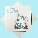 Easter greetings card with cute bunny rabbit, chocolate egg in pastel blue. 