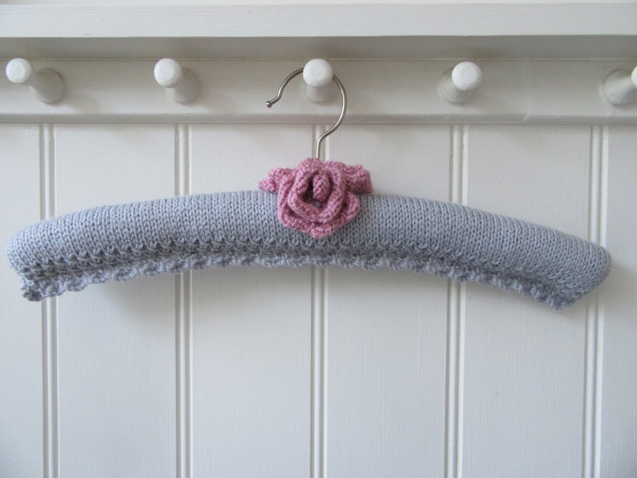 Hand knitted padded silver grey coat hanger with roses. 