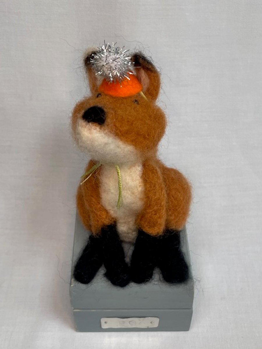 Handcrafted needle felted fox with removable party hat on a wooden box