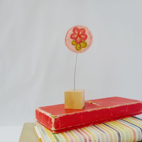 Pink flower fabric ornament on wooden block