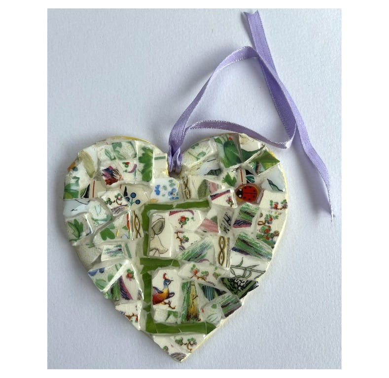 A heart shaped mosaic pendant with foliage and a subtlety discrete 18 or 81.