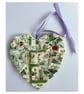 A heart shaped mosaic pendant with foliage and a subtlety discrete 18 or 81.