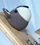 Crocheted wolf-type dog head on wooden board with hooks