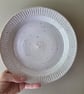 White speckled deep pottery plate with incised decorative edging 