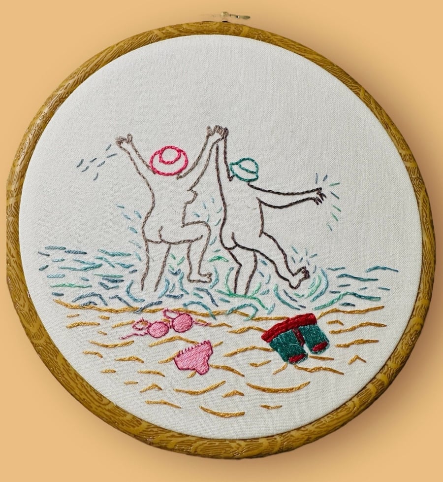 Hand embroidered picture of 2 naked skinny dippers.  Cheeky beach themed art