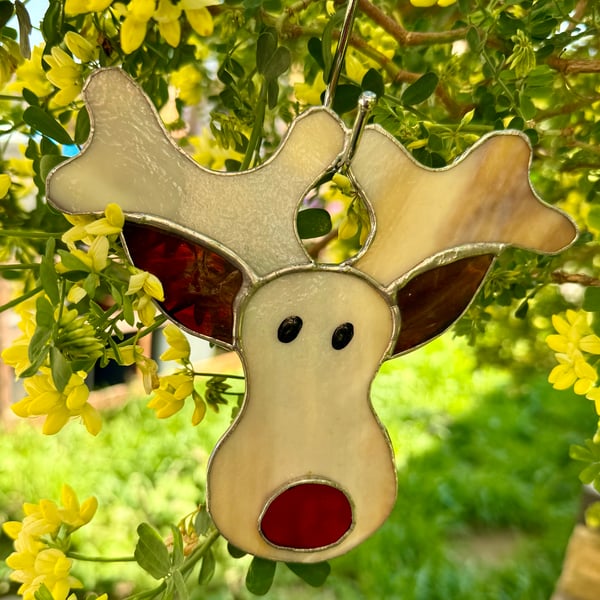 Stained glass reindeer suncatcher decoration in creamy browns with red nose