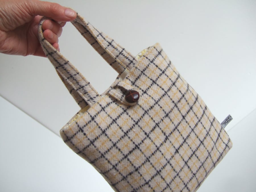 A little woollen bucket bag made from cream and black checked wool.