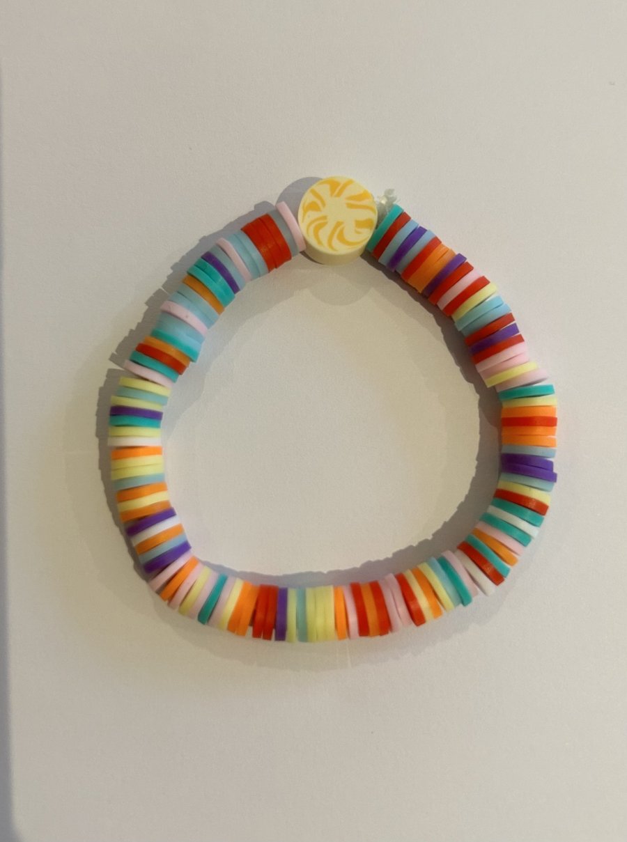 A multi coloured bracelet with yellow charm size medium 