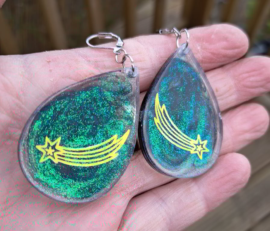 Shooting stars and green and black glitter oval shaped earrings