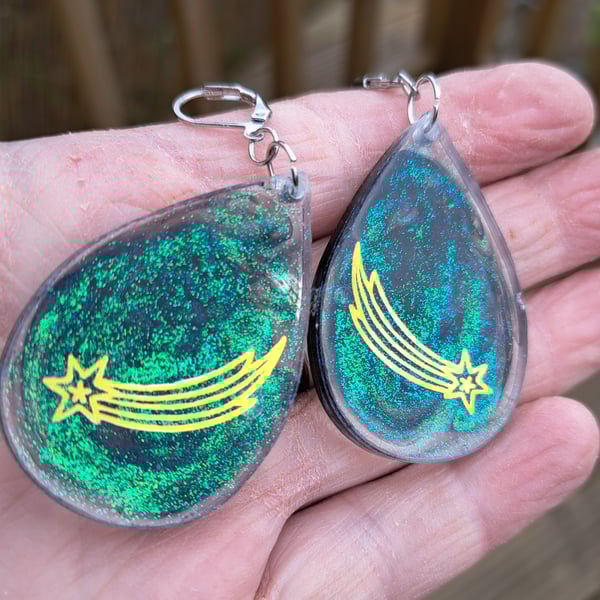 Shooting stars and green and black glitter oval shaped earrings