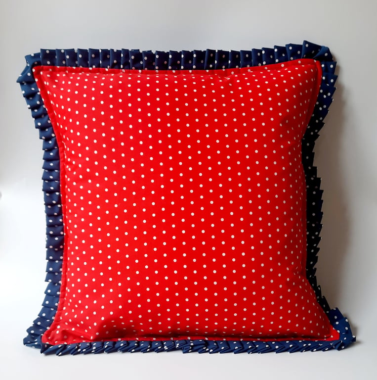 Red polkadot cushion cover with a navy polkadot pleated edge.  
