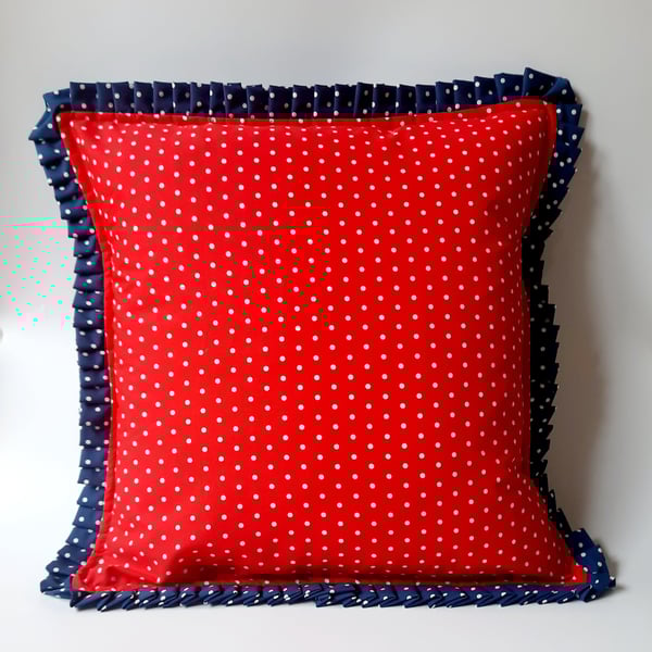 Red polkadot cushion cover with a navy polkadot pleated edge.  