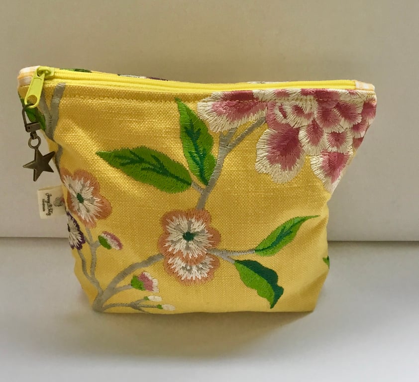 Golden yellow linen embroidered makeup bag.