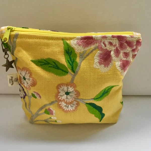 Golden yellow linen embroidered makeup bag.