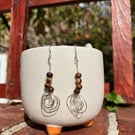 silver swirl dangle earrings with brown beads - strength