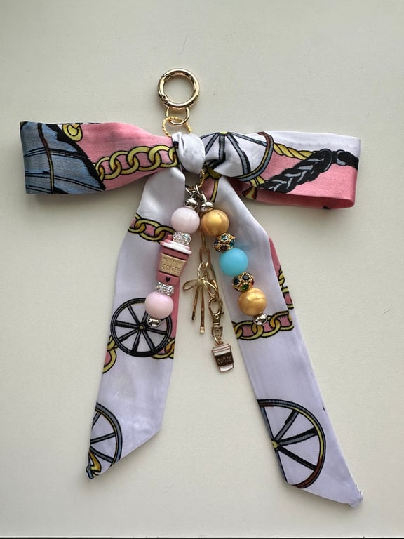 Hand crafted bag charm features a satin scarf bow, beaded dangles 