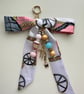 Hand crafted bag charm features a satin scarf bow, beaded dangles 