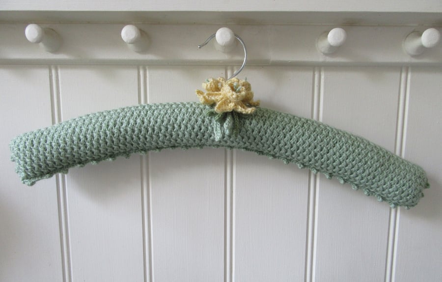 Hand knitted green coat hanger with daffodils